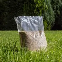 bag full of grass seeds outdoor on green grass