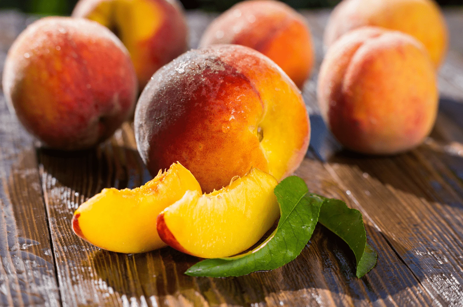 Fresh sweet group of sliced peaches on wooden table