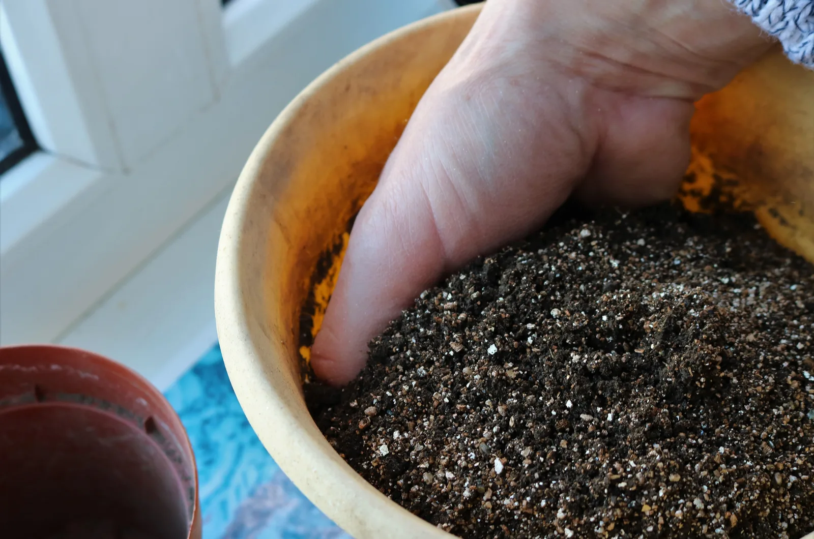 hand mixing soil and vermiculite