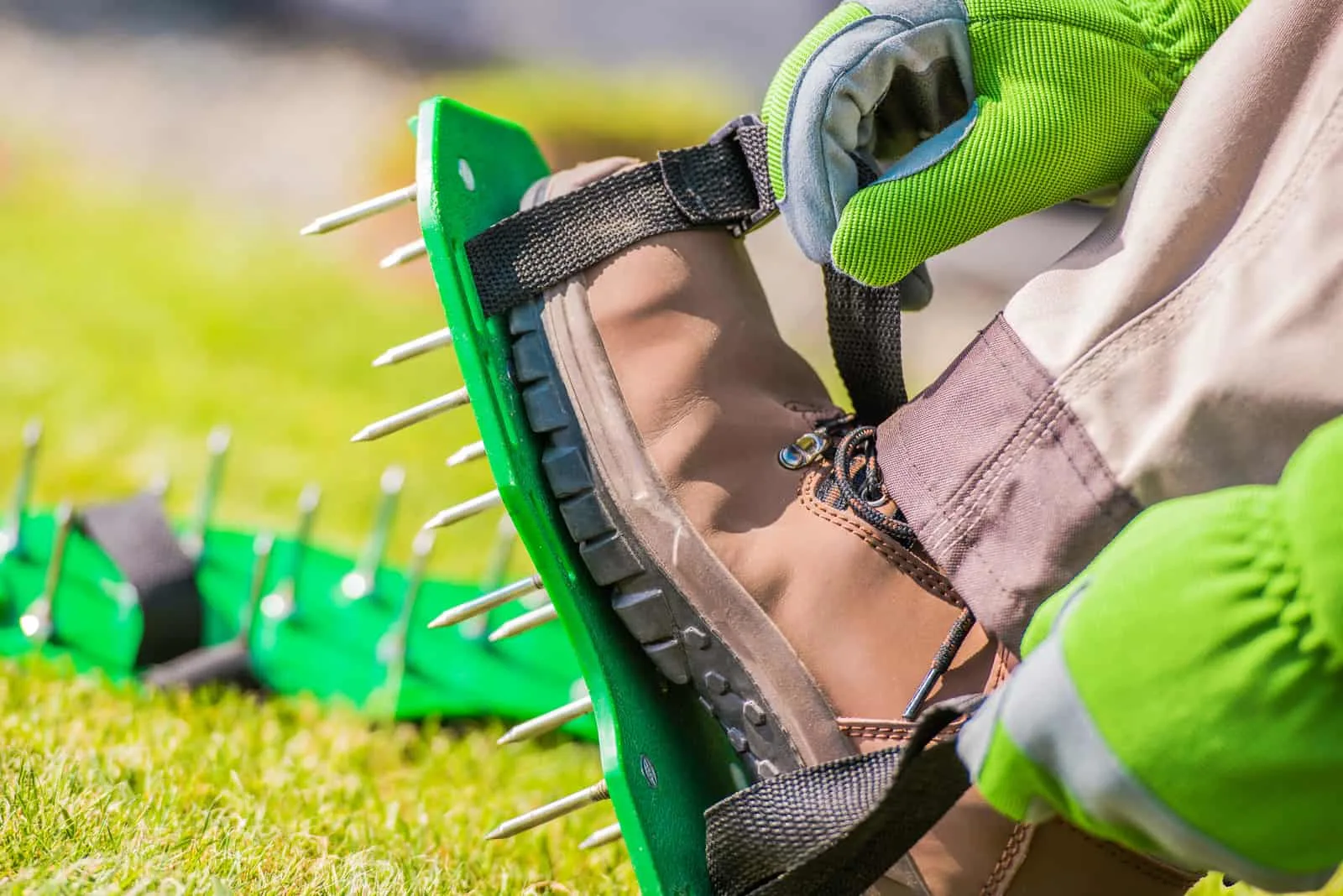 men aerating his lawn strapping on these spiked shoes