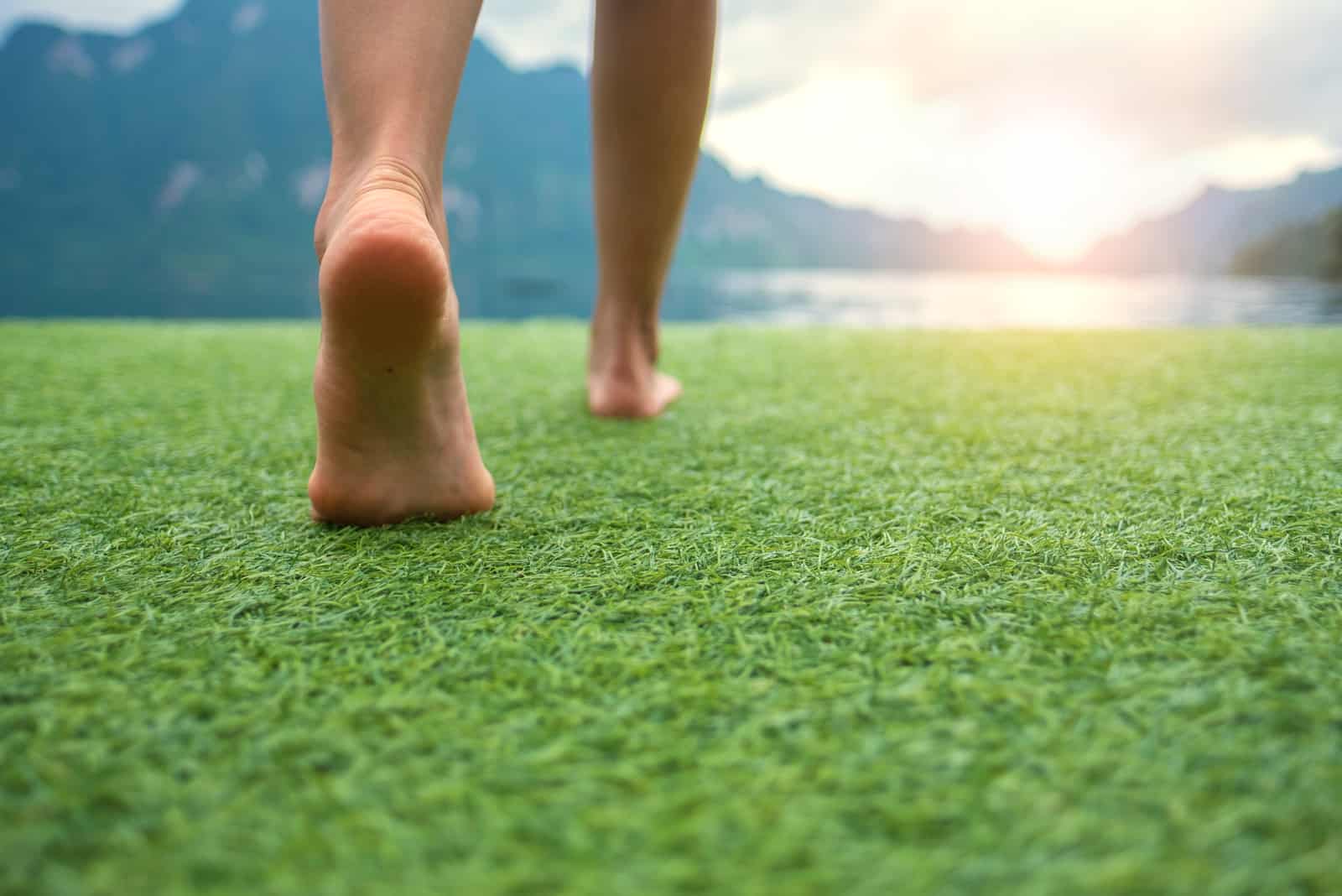 woman walking barefoot on grass