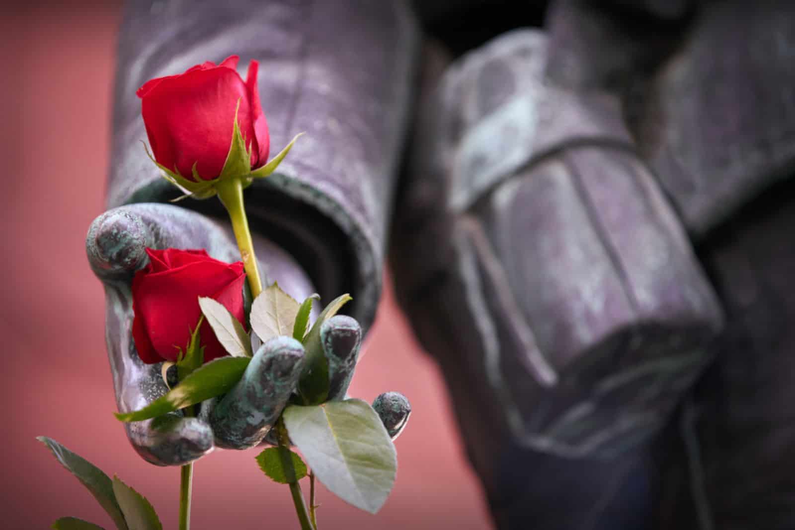 Red roses on a close up of a statue of a world wa