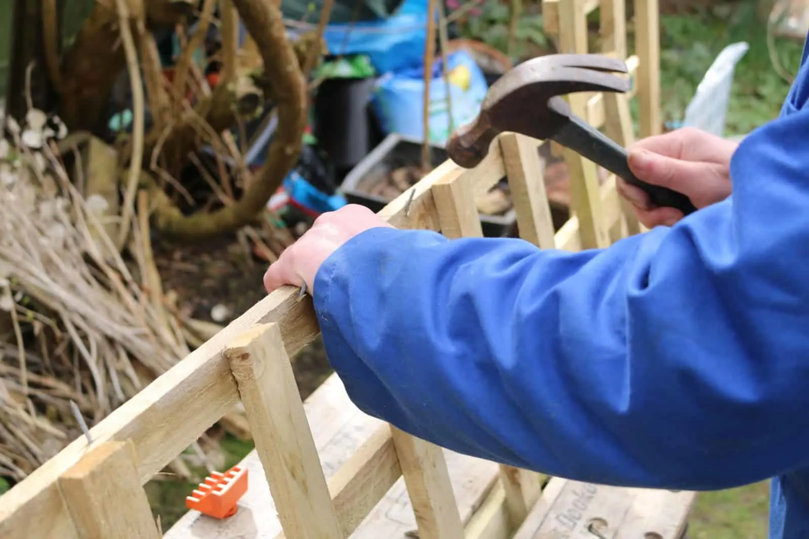 Worker assembling a piece of wooden trellis