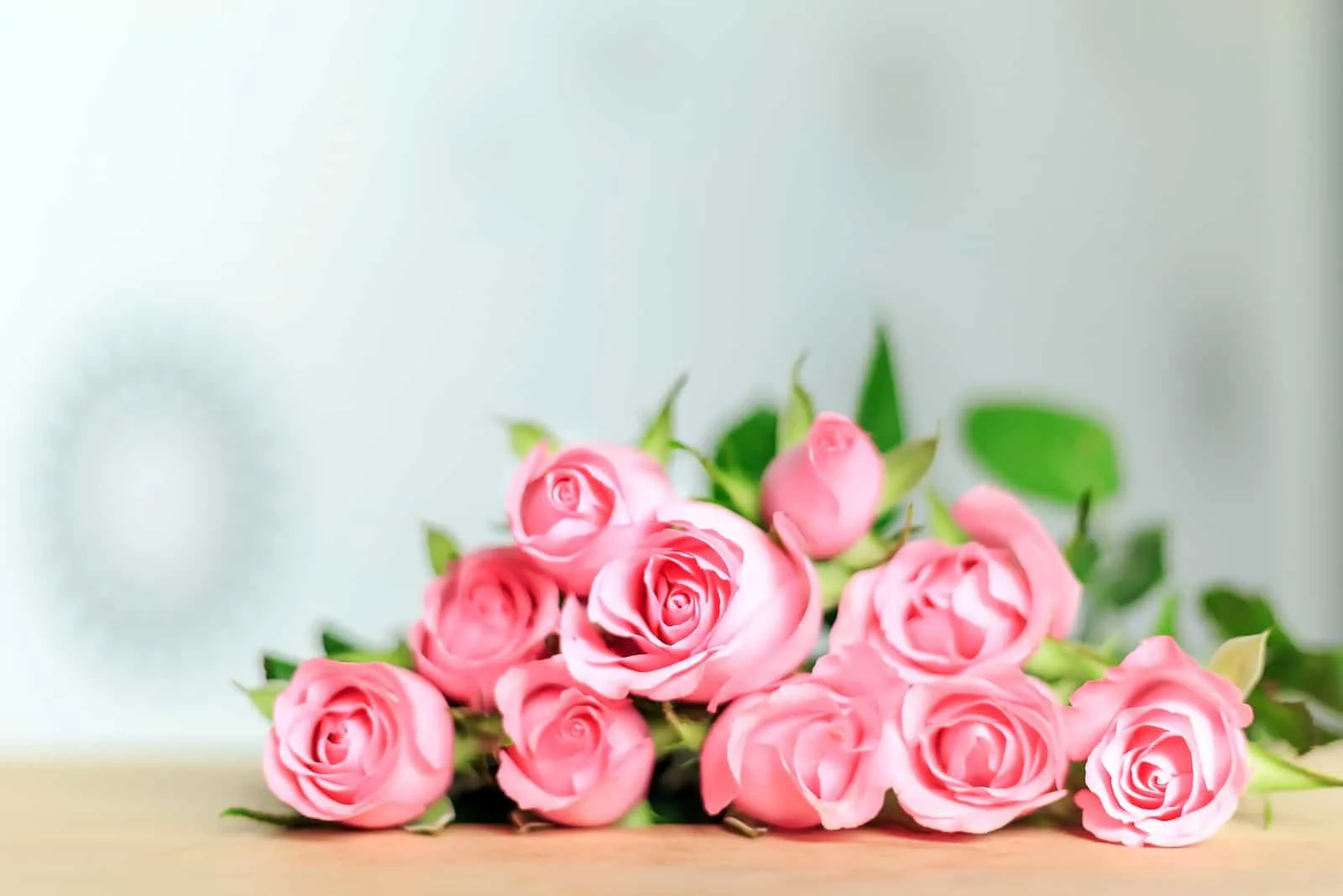 group of pink roses on wooden table