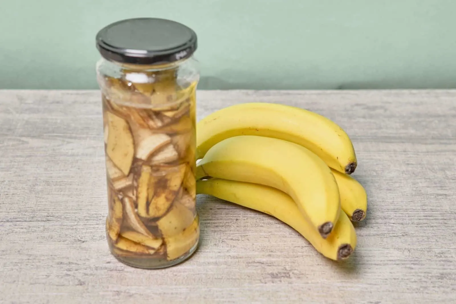 A jar filled with banana peel cuts and water