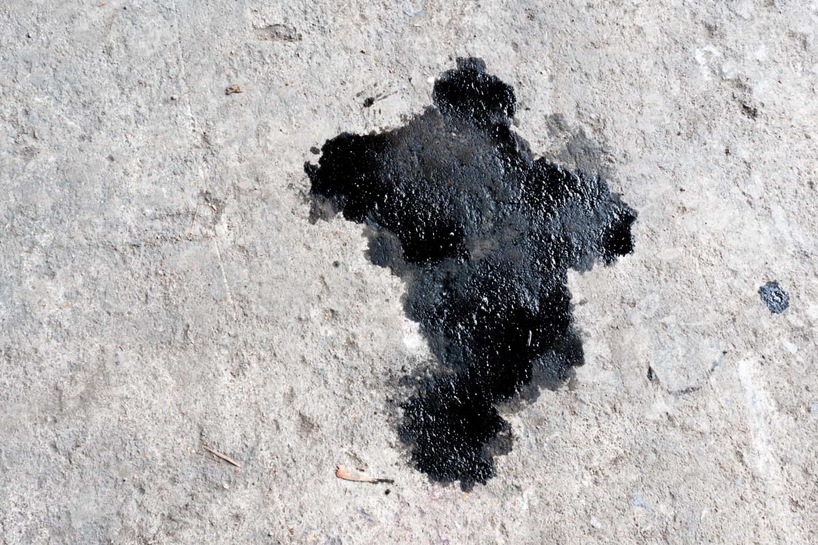 Abstract black engine oil drop on concrete floor texture backgruond.