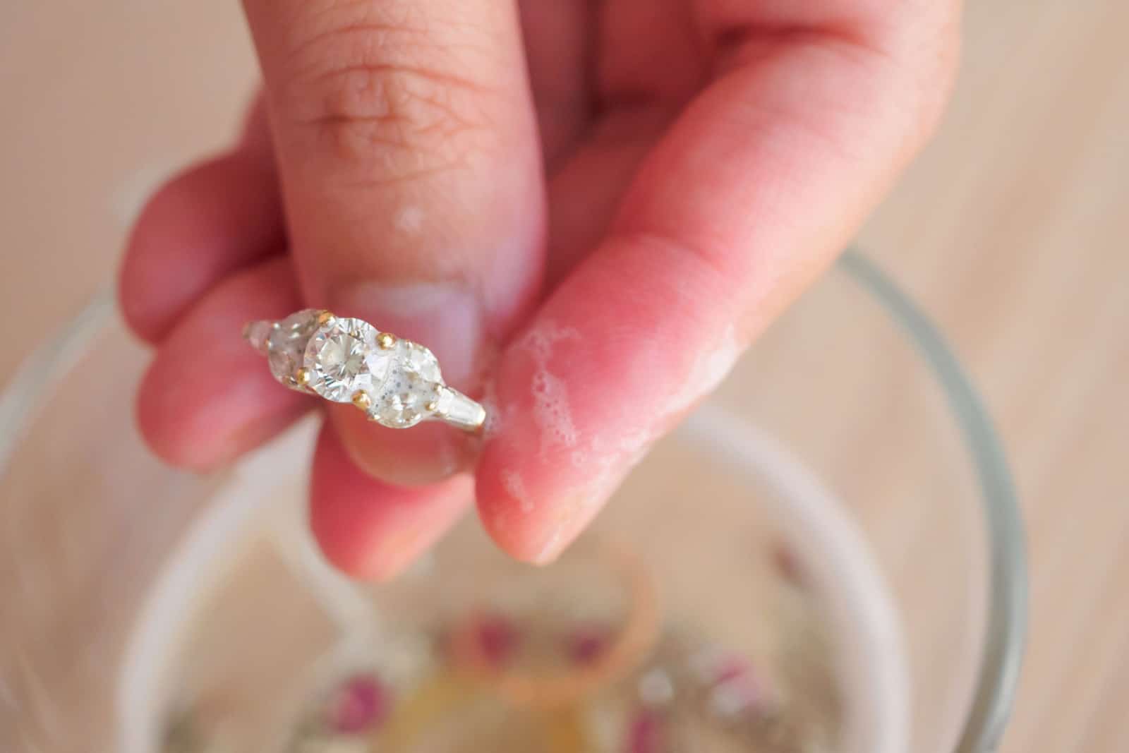 Jeweller hand cleaning vintage jewelry diamond ring closeup