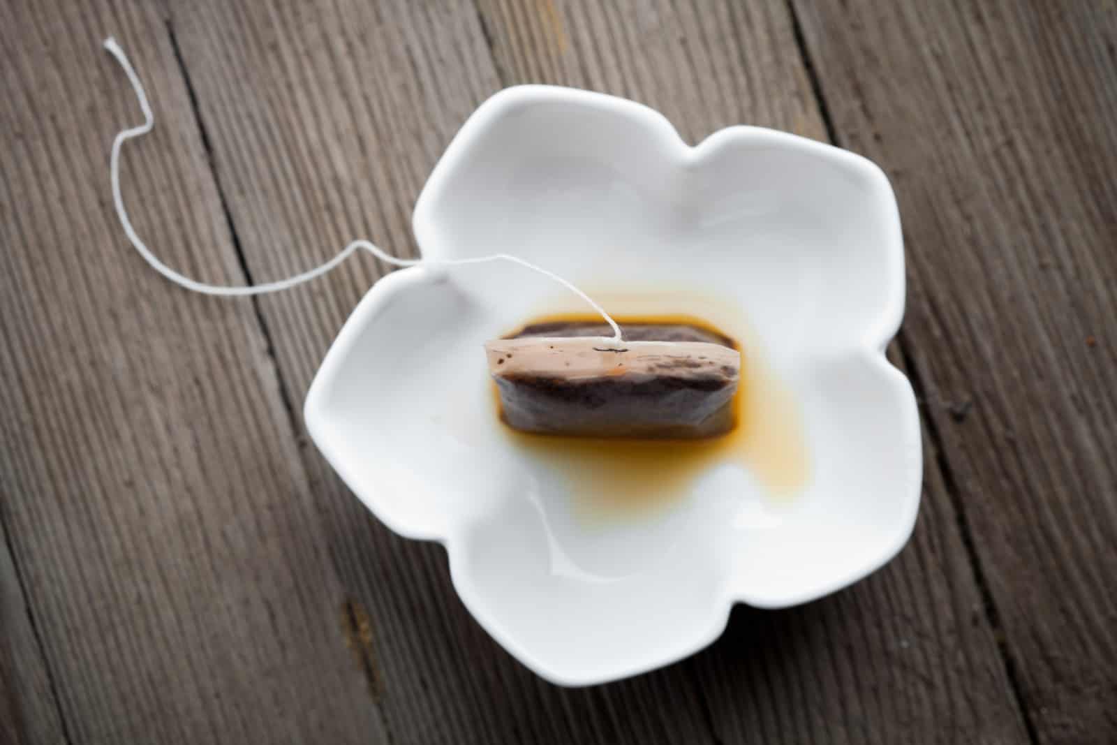 Used tea bag in small white bowl