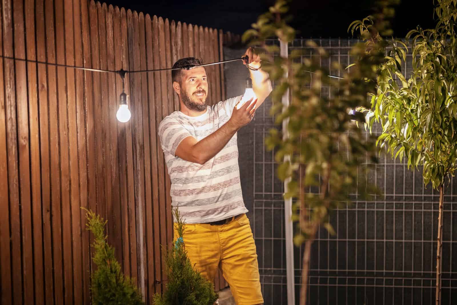 a man makes lighting in the garden