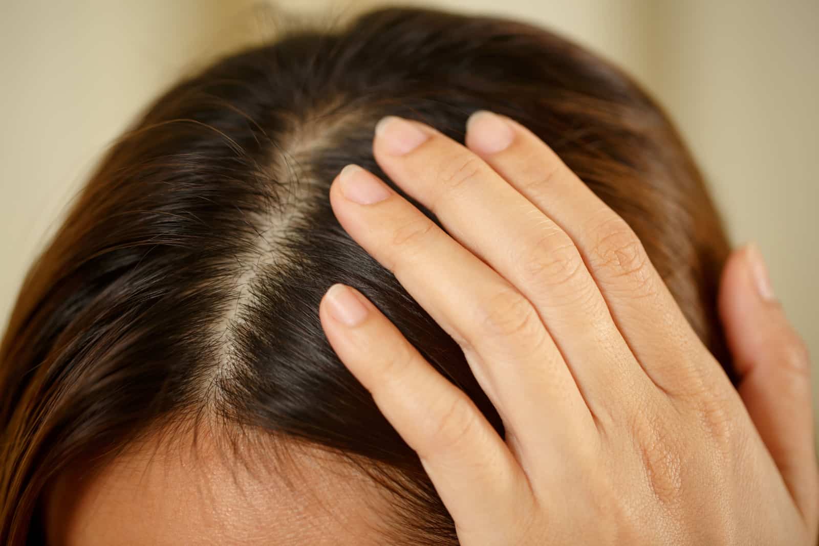 woman touches her scalp