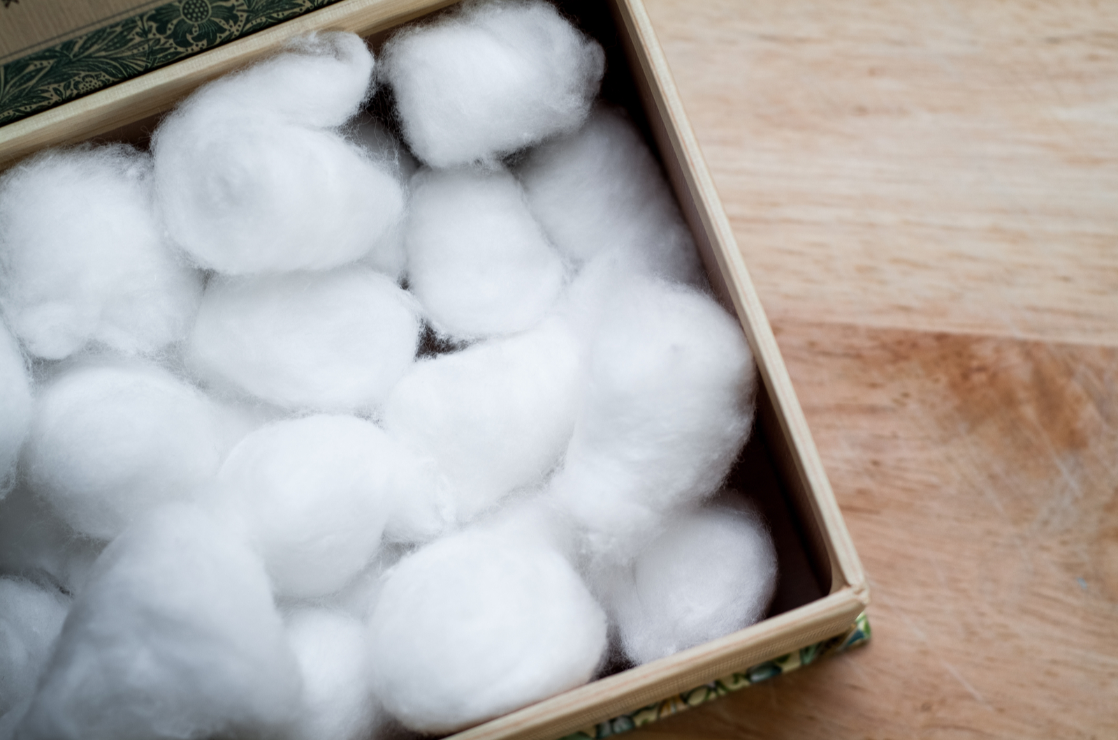 close-up photo of a cardboard box full of white cotton balls