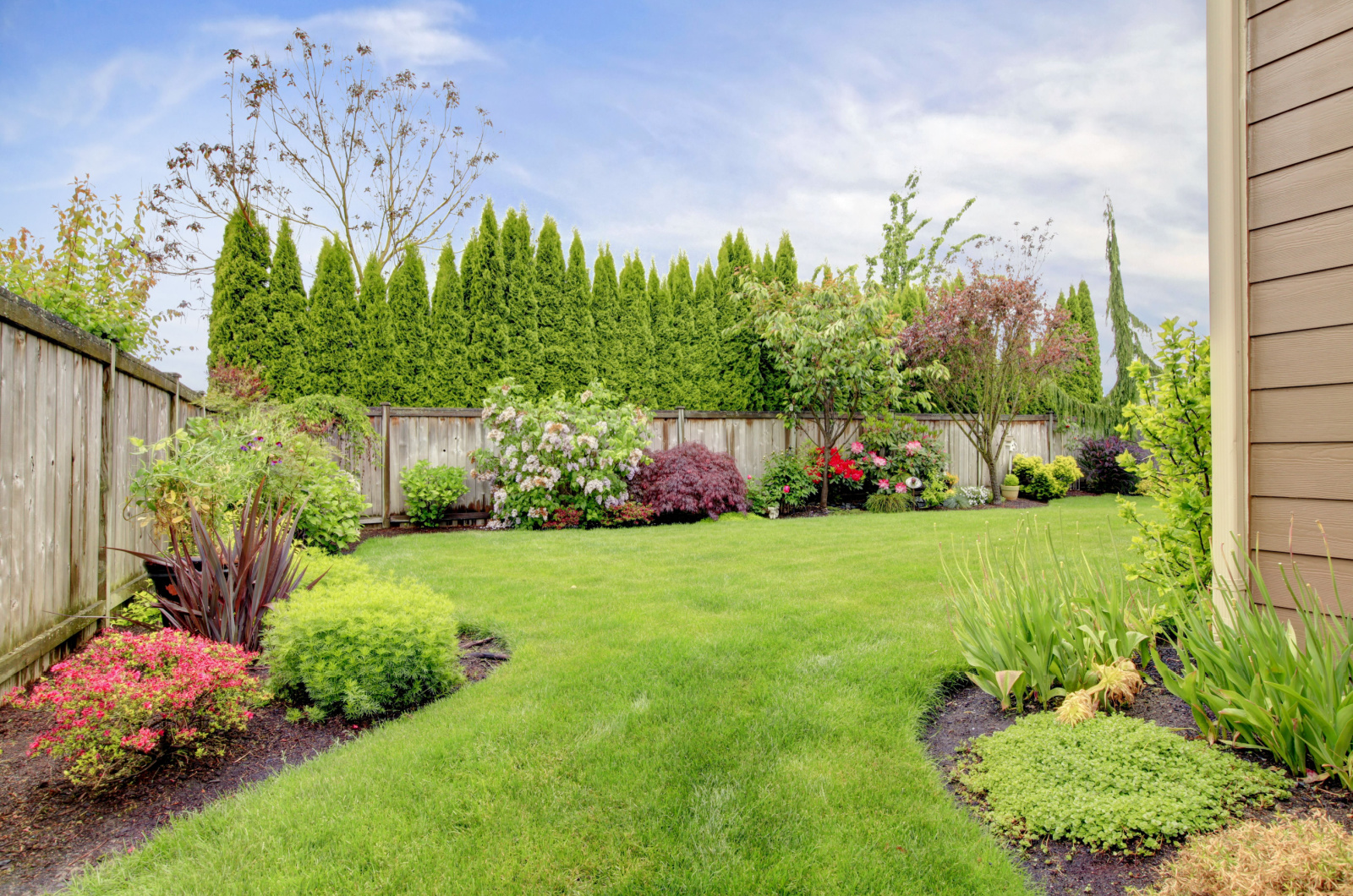 photo of fenced yard with flower beds