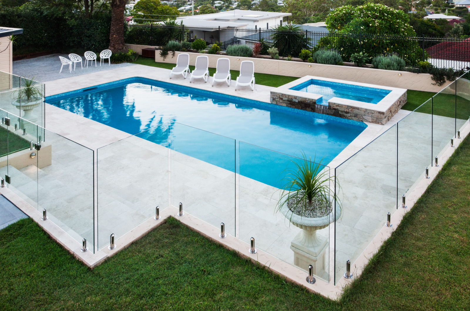 glass fence in a modern yard with a pool