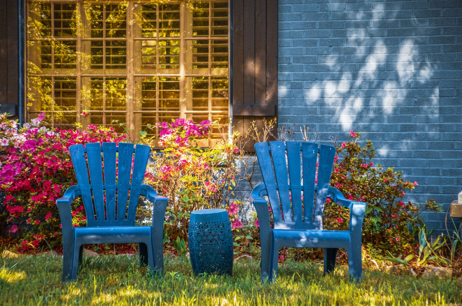 Two blue chairs and table on lawn
