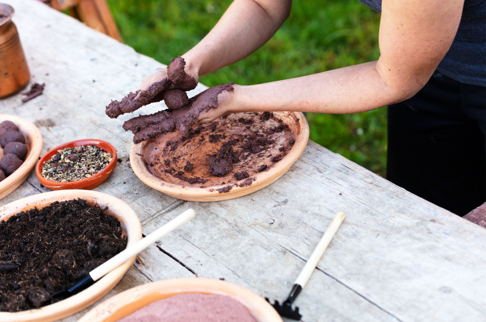 woman is making seed bombs on a wooden table