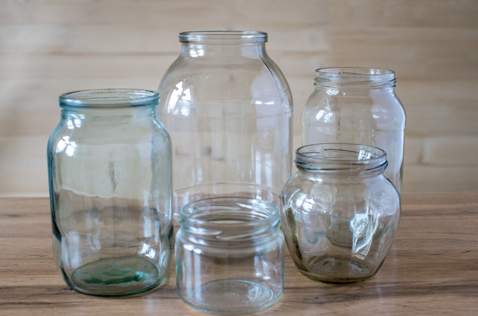 Glass jars of different sizes and volumes on the wooden table