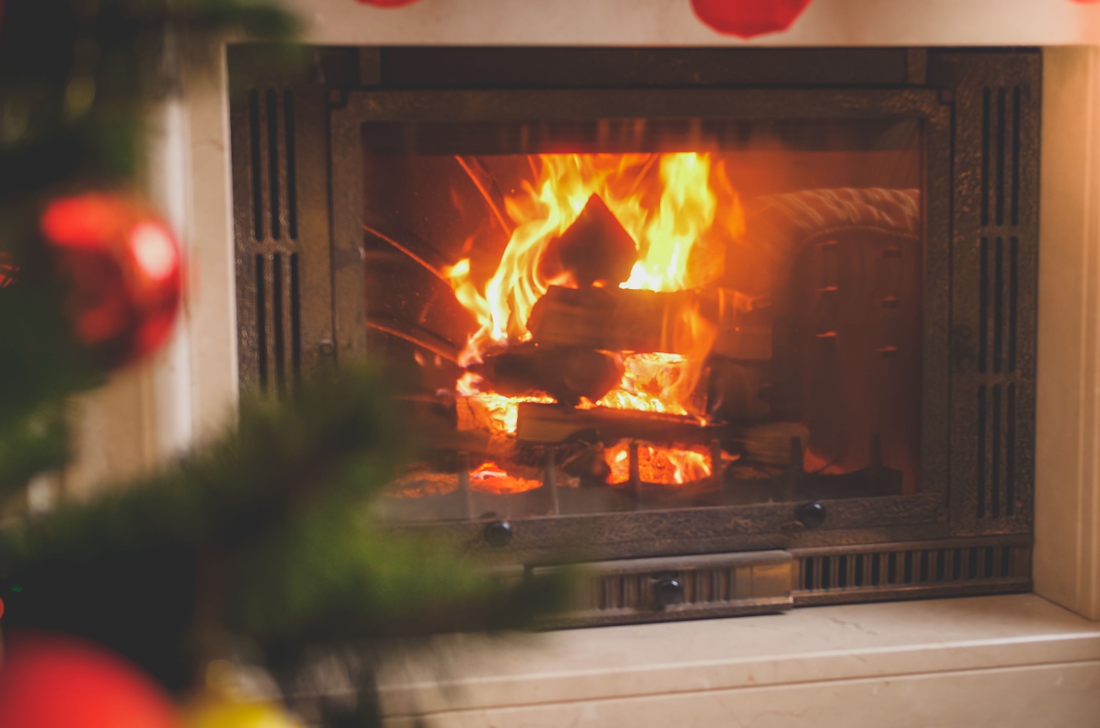 christmas tree next to a fire place