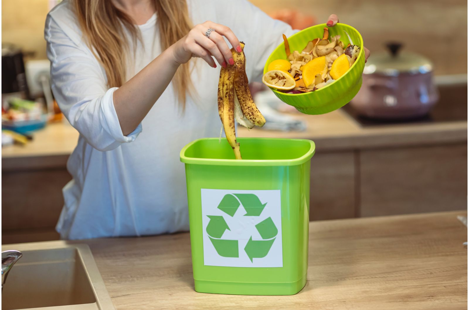 woman placing food waste in a bin