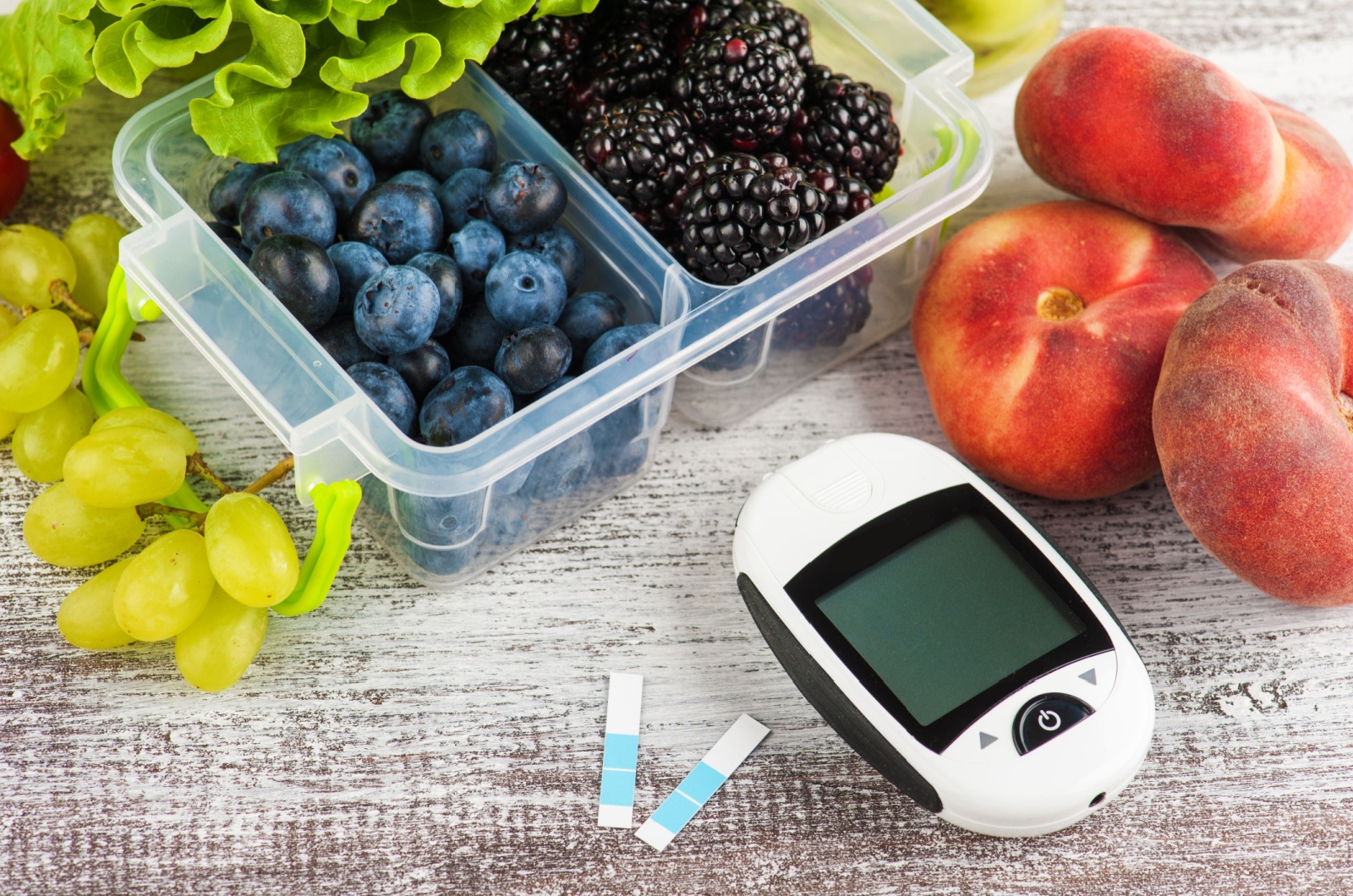 Blood glucose meter, berries and fruits