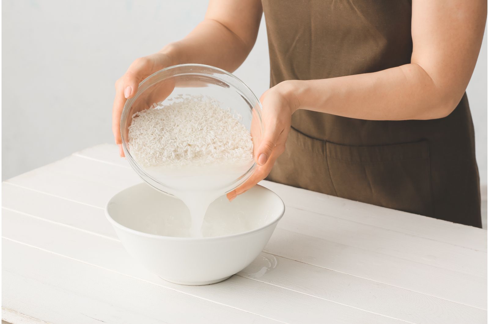 woman pouring rice water in bowl