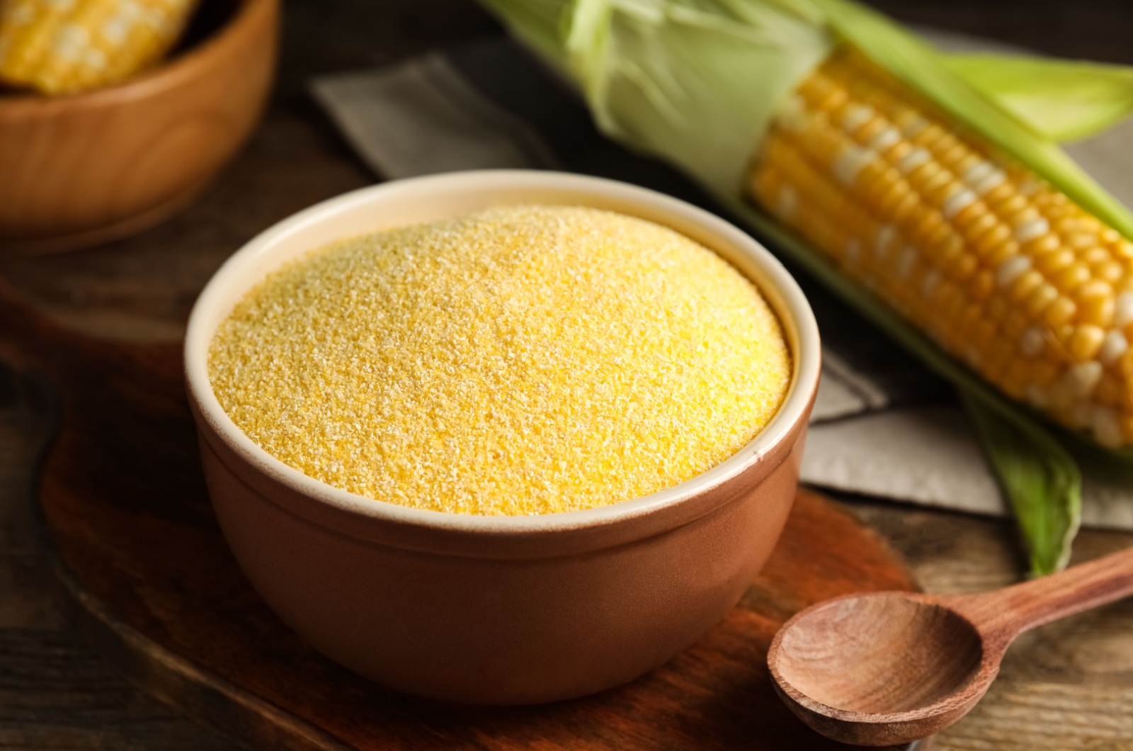 Cornmeal in bowl on wooden table