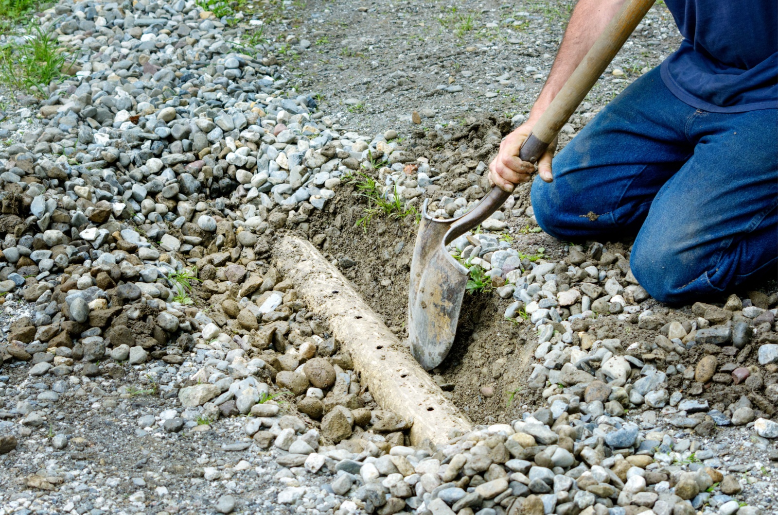Man digging out french drain