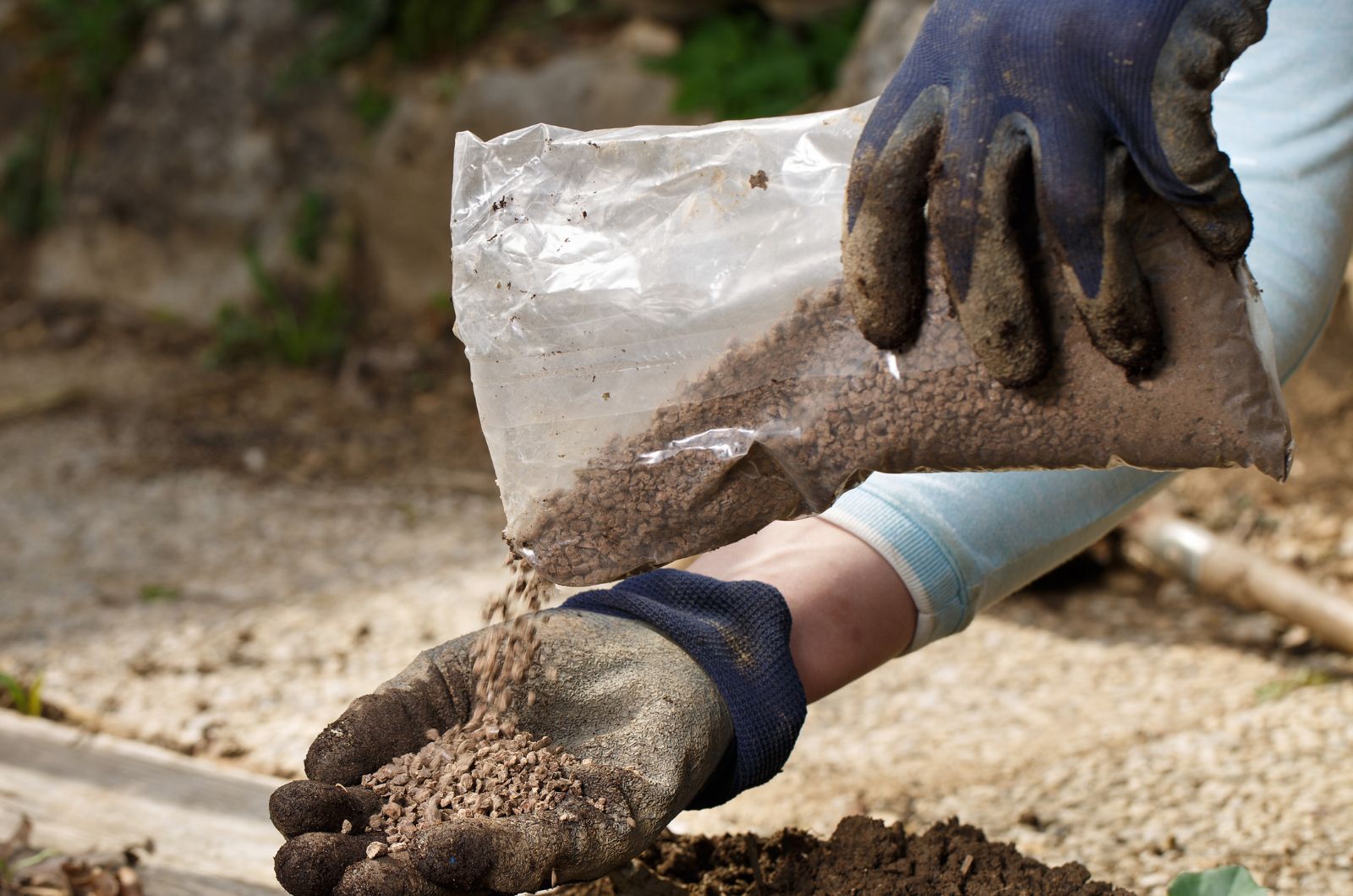 gardener blending fertilizer with soil