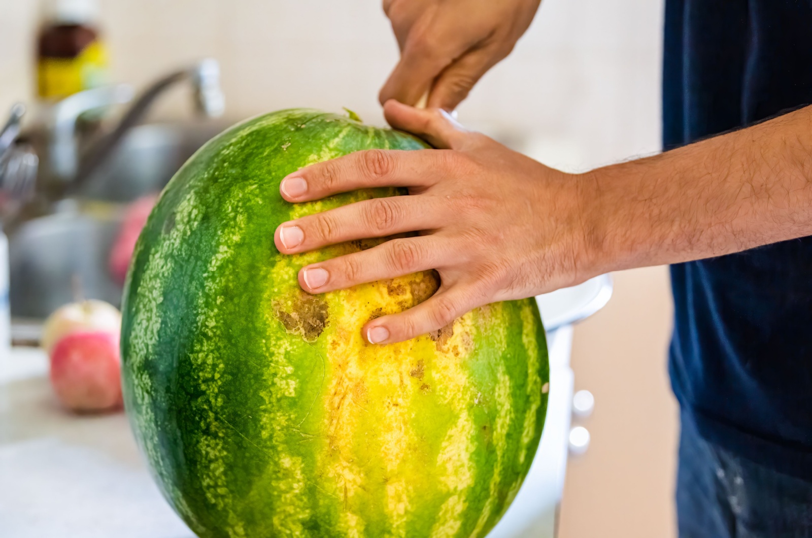 man cutting watermelon in half