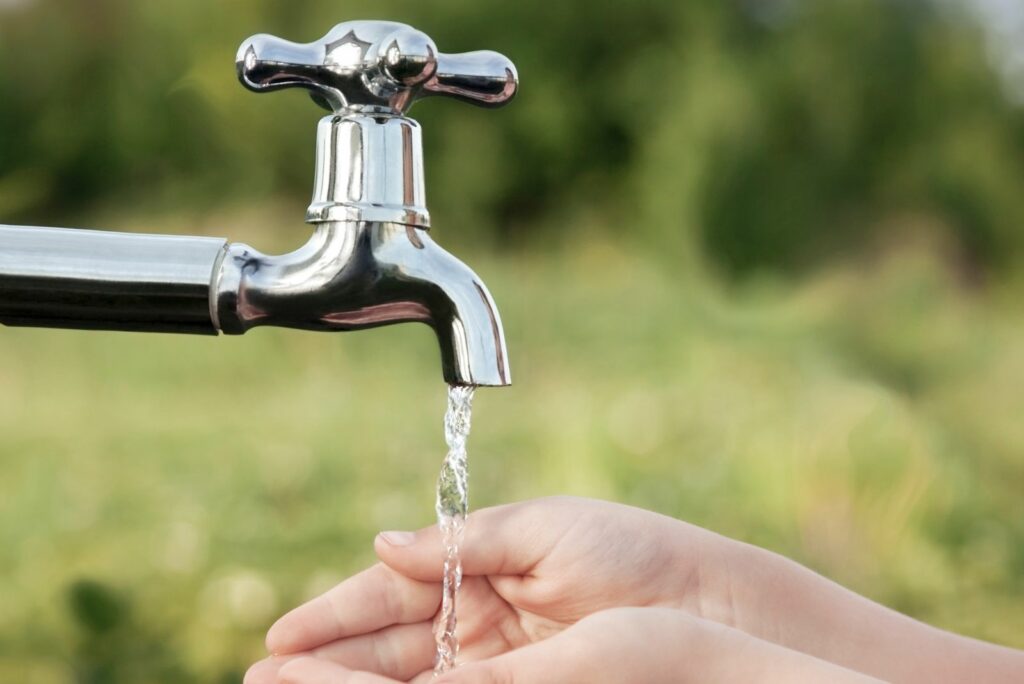 a man washes his hands from the tap