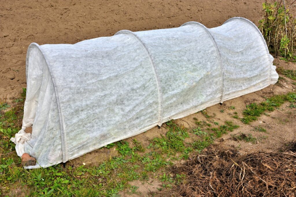 Mobile greenhouse on a garden bed on an autumn day