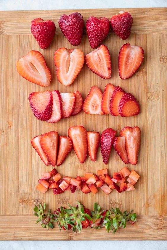 sliced ​​strawberries on a wooden board