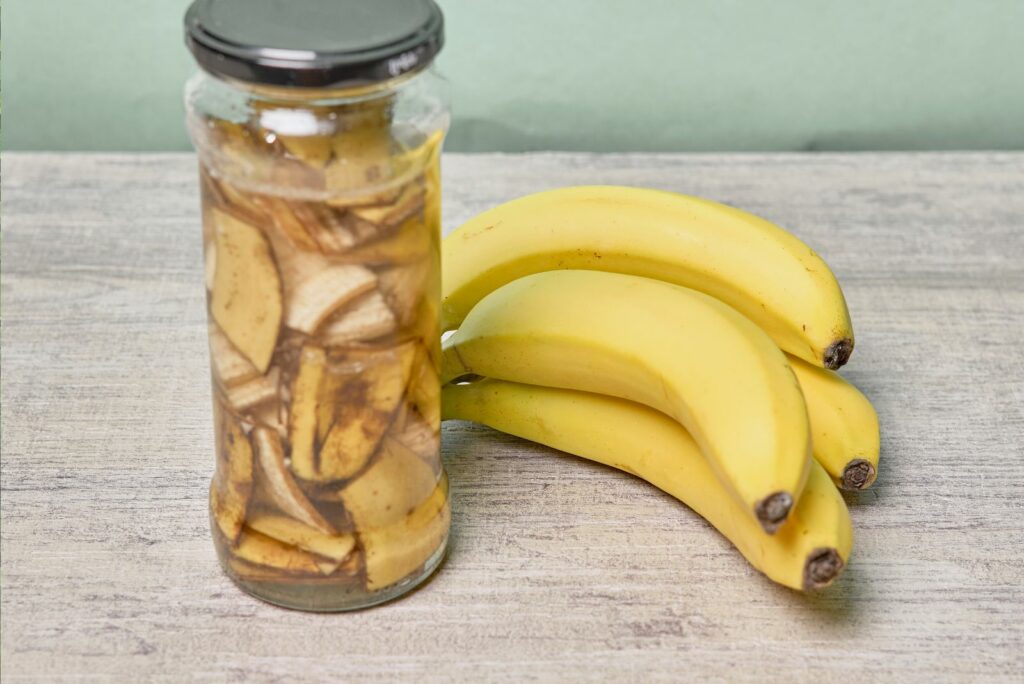 A jar filled with banana peel cuts and water