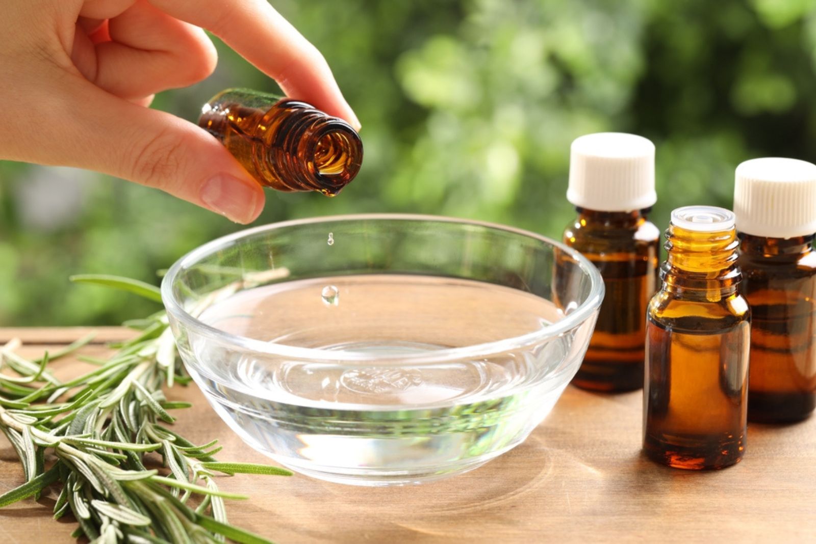 Woman dripping essential oil into bowl