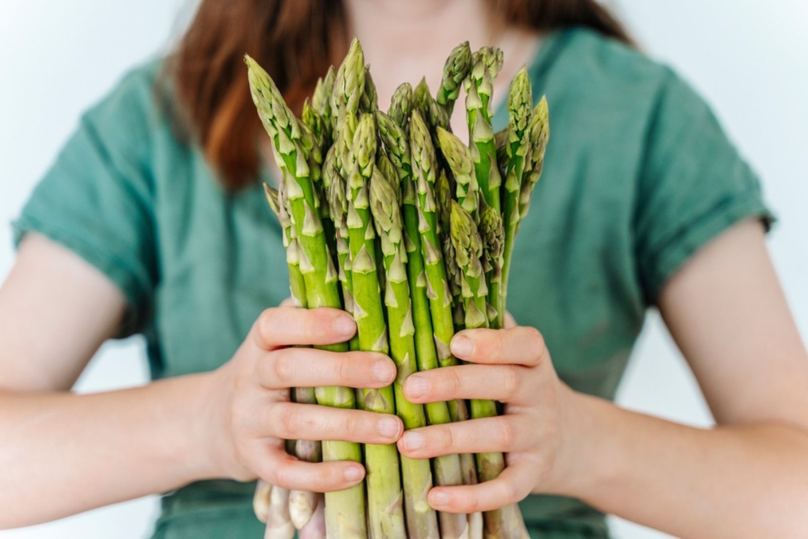 woman holds asparagus in hands