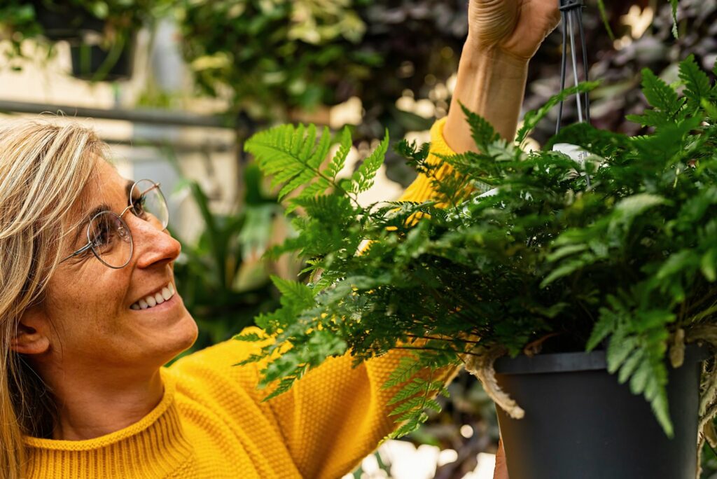 woman inspects fern