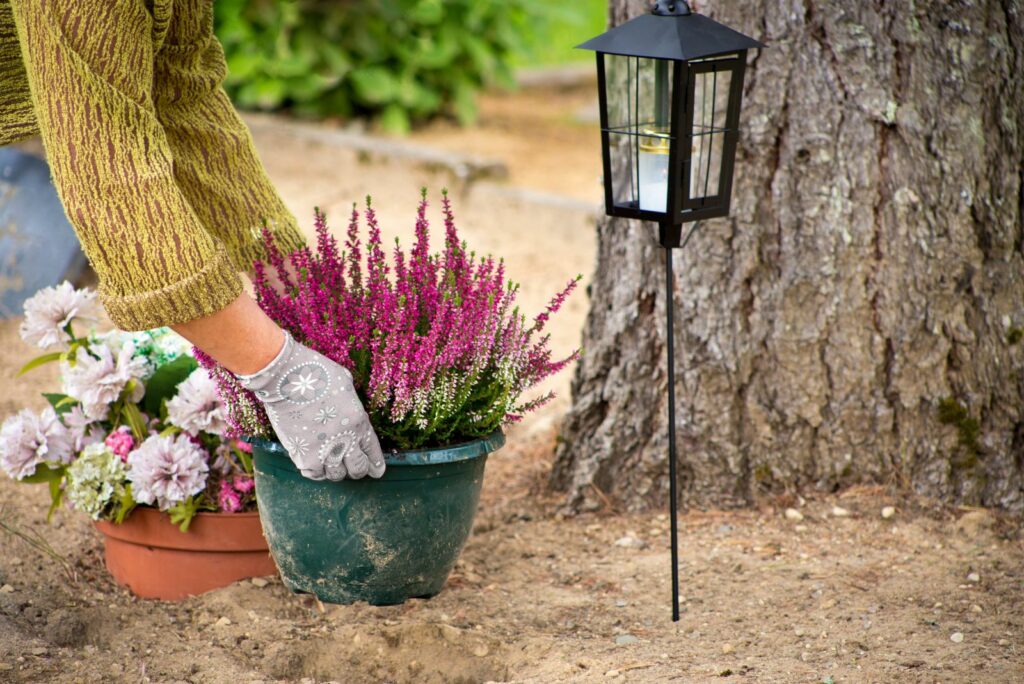 A woman is cleaning a flower pot outside