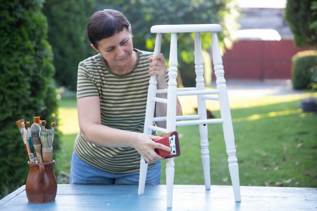 A woman is fixing an old chair