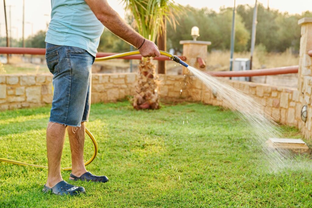 a man is watering the lawn