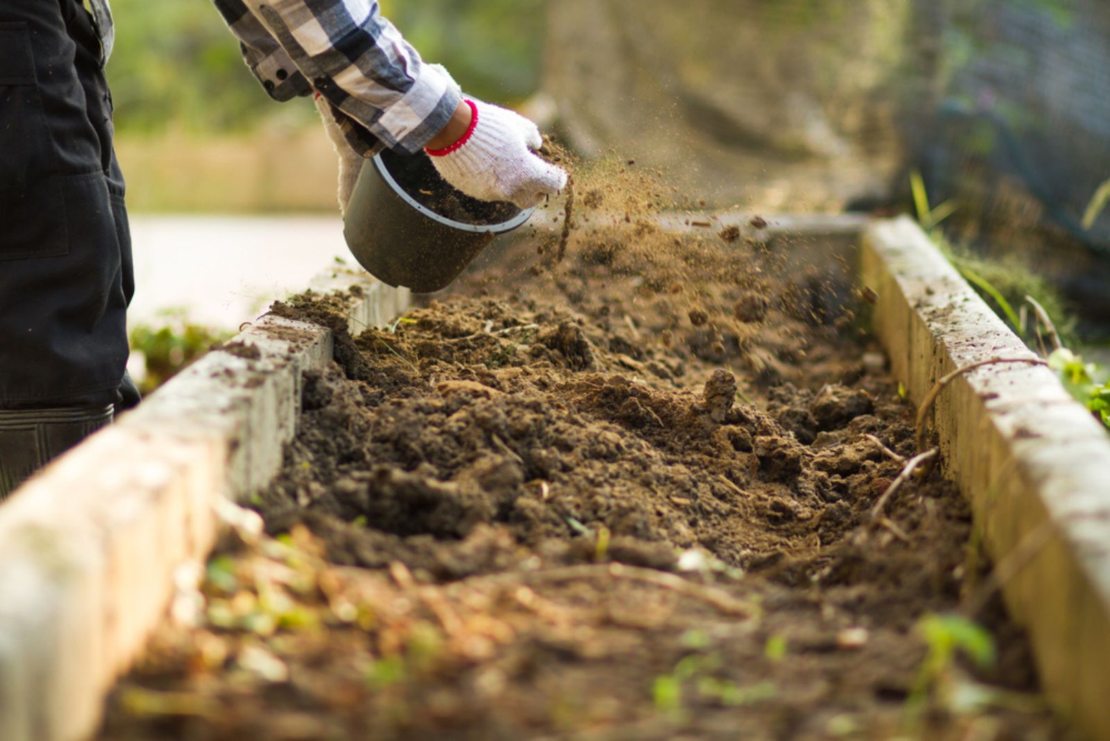 gardener mixing soil with compost