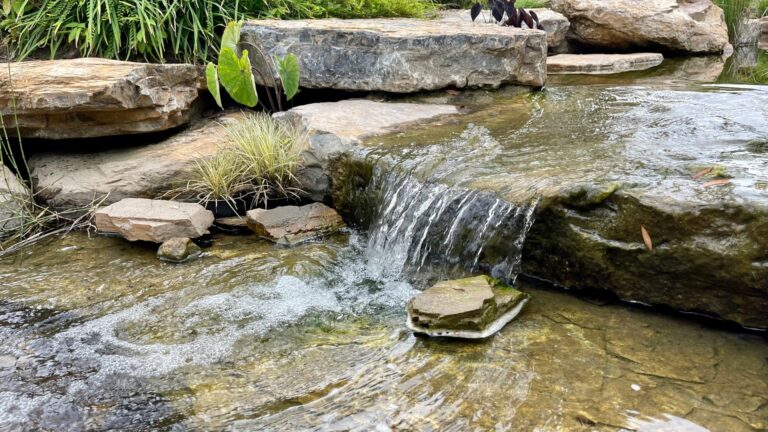 Beautiful small waterfall made from big rock and river stone decorated in the garden