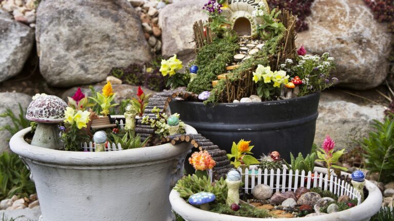 Fairy garden in a flower pot with walking path, wooden bridges and a fairy house.