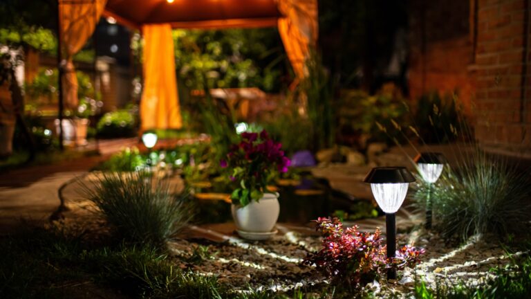 Decorative Small Solar Garden Light, Lanterns In Flower Bed. Garden Design. Solar Powered Lamp