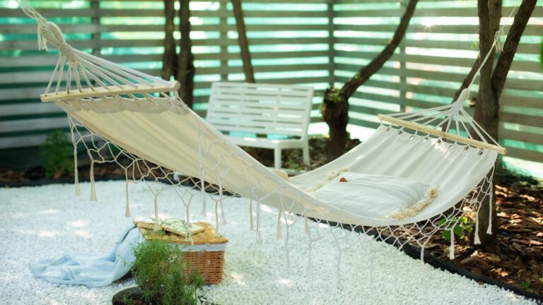 Cozy exterior backyard. Hammock in boho style hanging on tree.