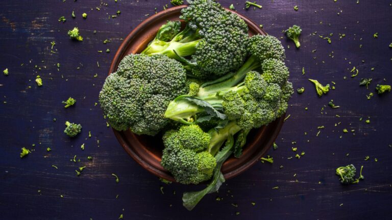 Fresh raw broccoli on a wooden table, top view, copy space