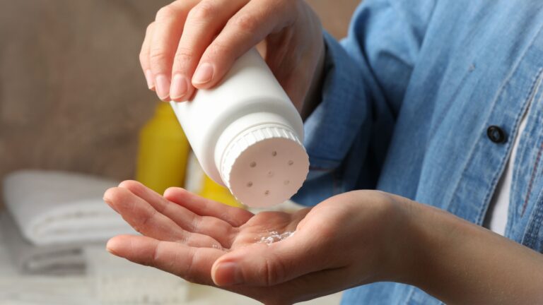 woman sips baby powder on her hand