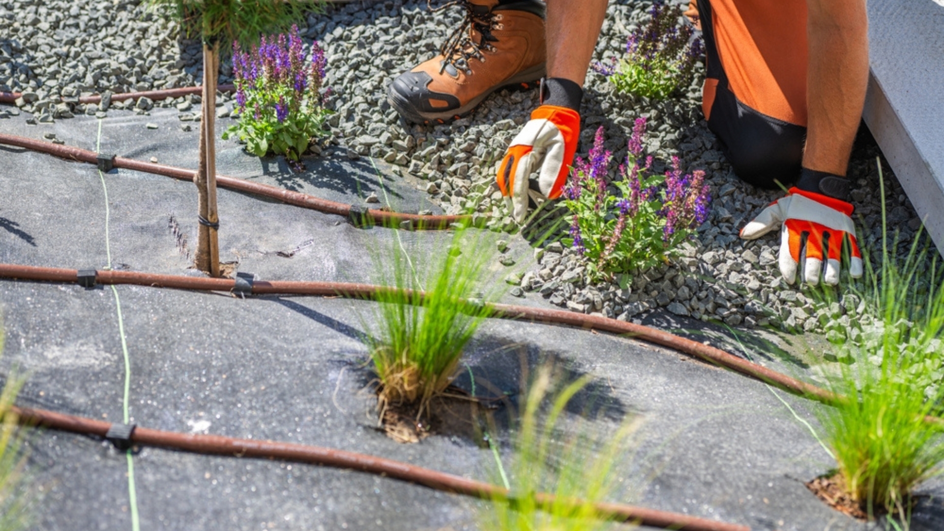 man spreading gravel over the ground