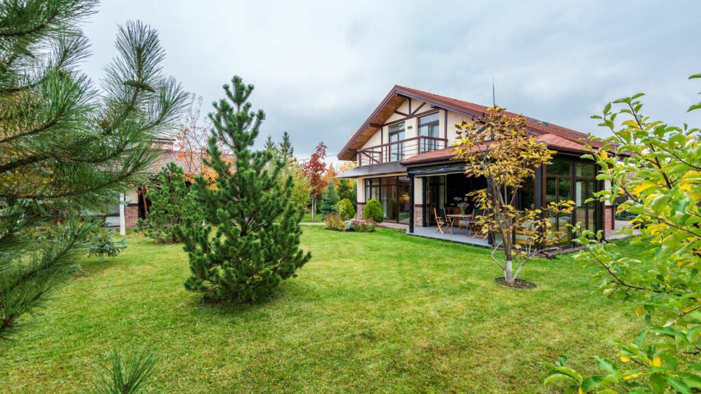 Cottage with veranda and trees growing in backyard