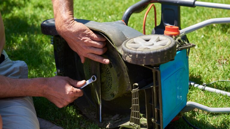 man sharpens lawn mower blade