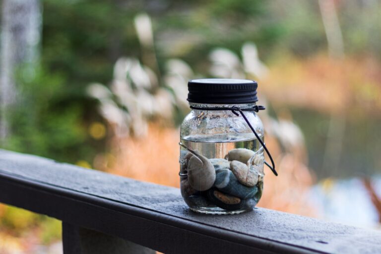 mason jar filled with rocks on a fence