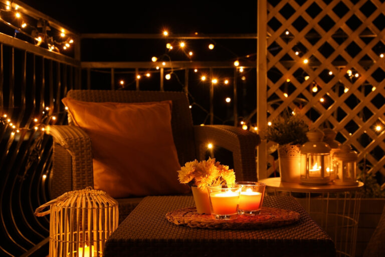 Beautiful view of garden furniture with pillow and burning candles at balcony (featured image)